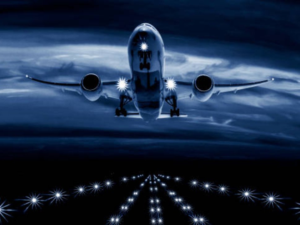 A passenger plane takes off from the night airport runway